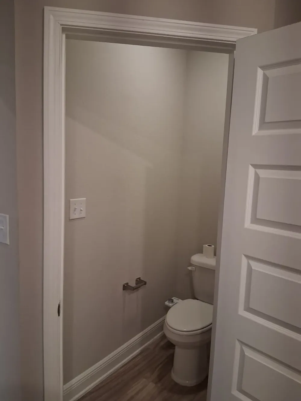 Finished powder room with fresh paint, trim, and flooring
